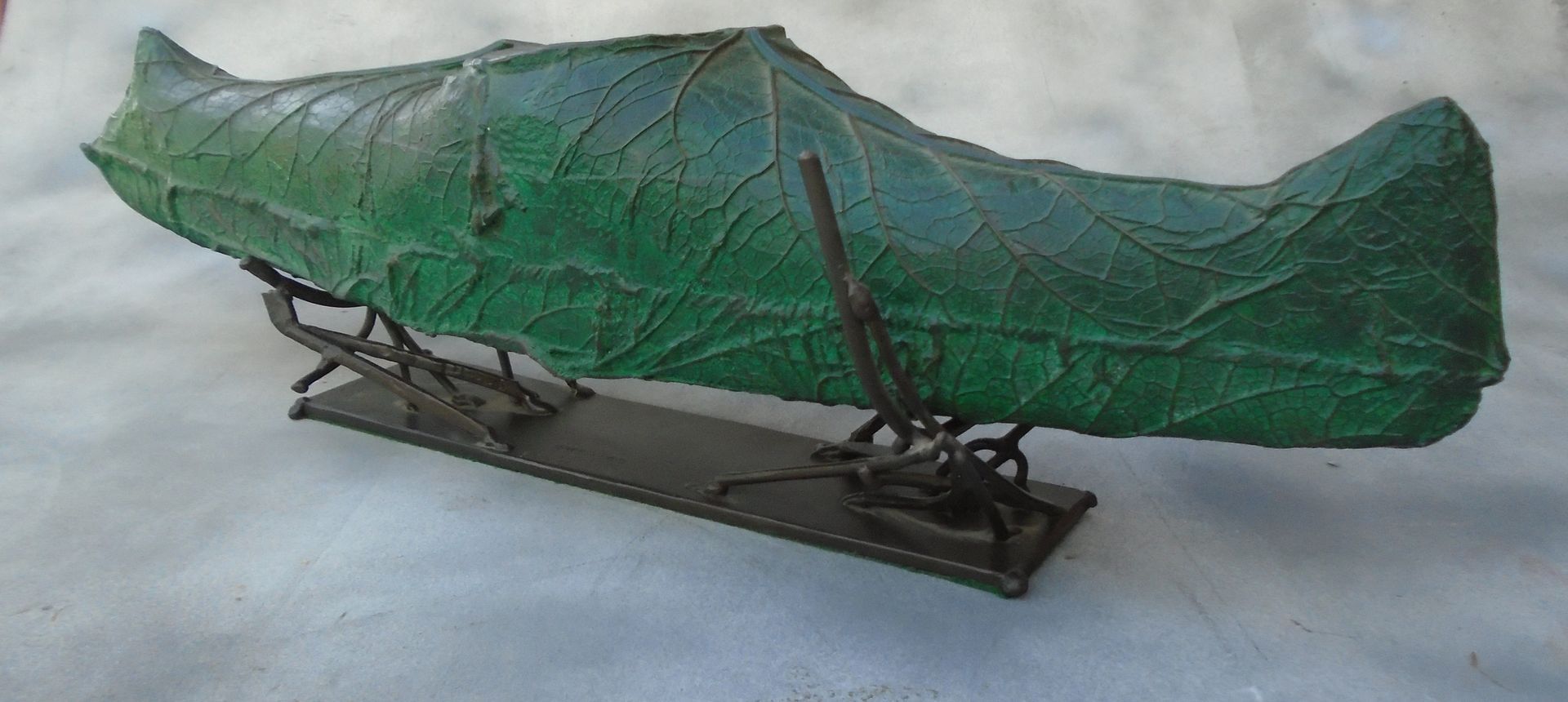 Green tarp-covered object on a metal wheeled frame