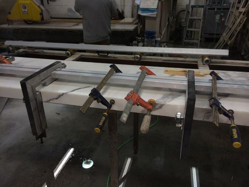 Marble countertop clamped for repair in a workshop.