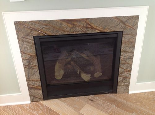 Fireplace with brown and tan stone surround, black frame, and white trim.