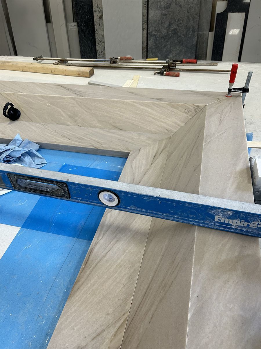 A level rests on assembled stone pieces with clamps, suggesting construction or repair work.