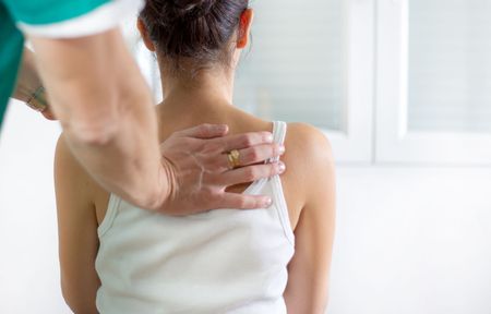 A woman is getting a massage from a doctor.