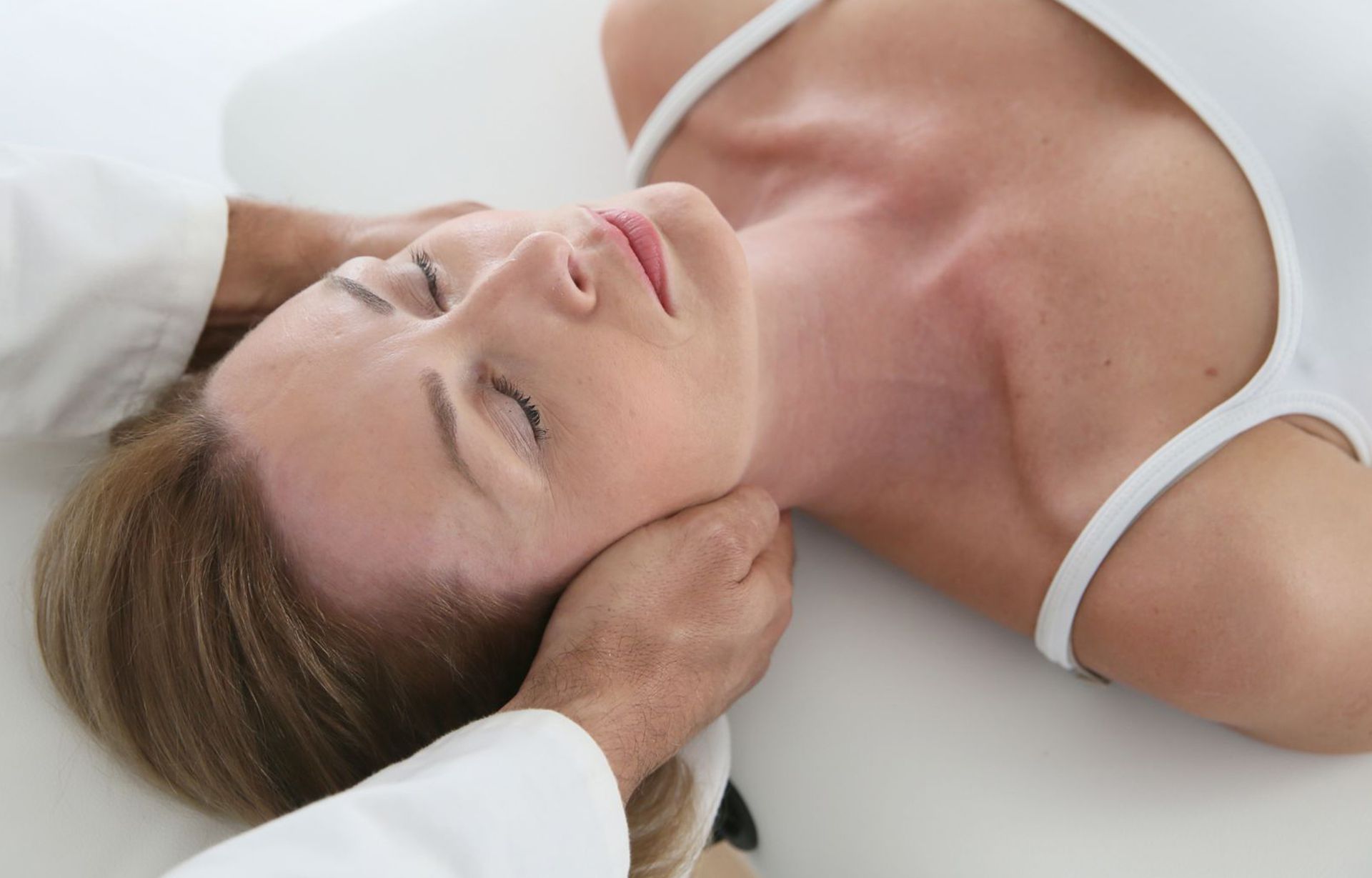 A woman is getting a neck massage from a doctor.