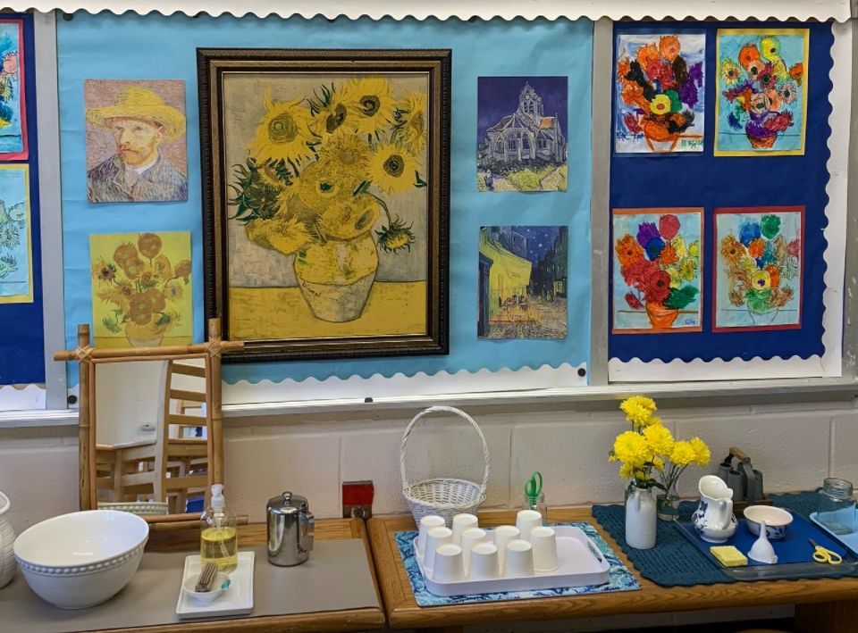 A classroom with a bunch of paintings on the wall