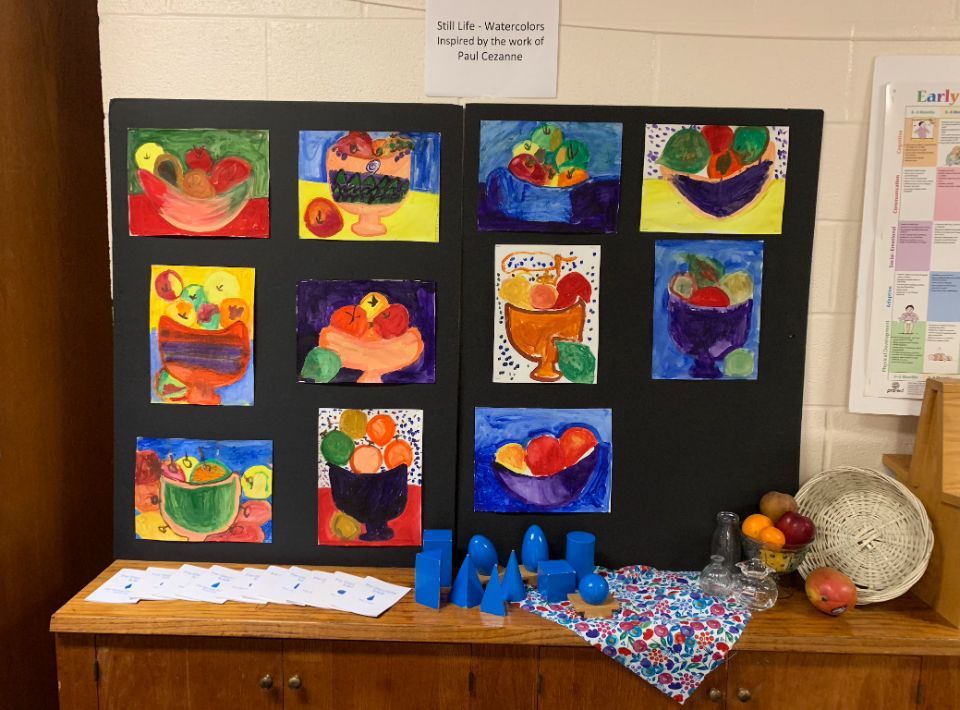 A display of children 's paintings of fruit in bowls