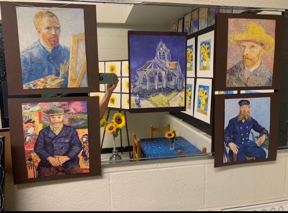 A person is taking a picture of a painting of vincent van gogh