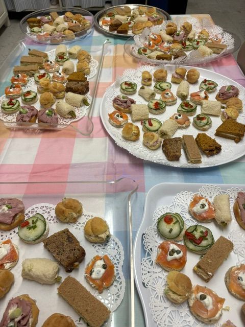 A table topped with plates of food including sandwiches