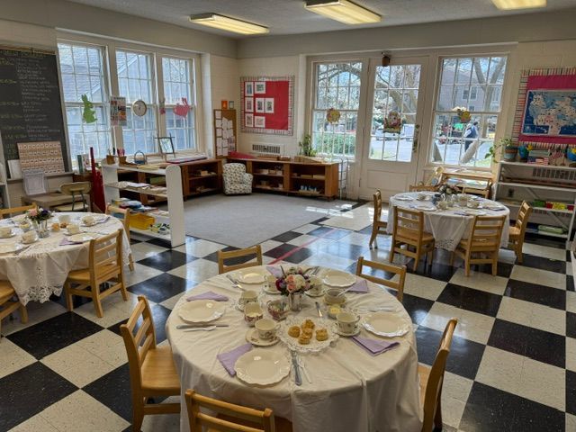 A classroom with tables and chairs set up for a tea party