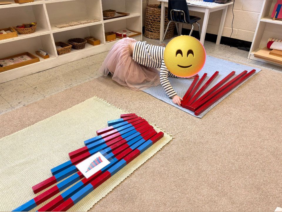 A little girl is laying on the floor with a yellow smiley face on her head