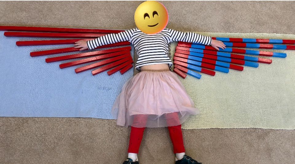 A little girl is laying on the floor with a yellow smiley face on her head