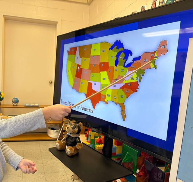A person pointing at a map of the united states