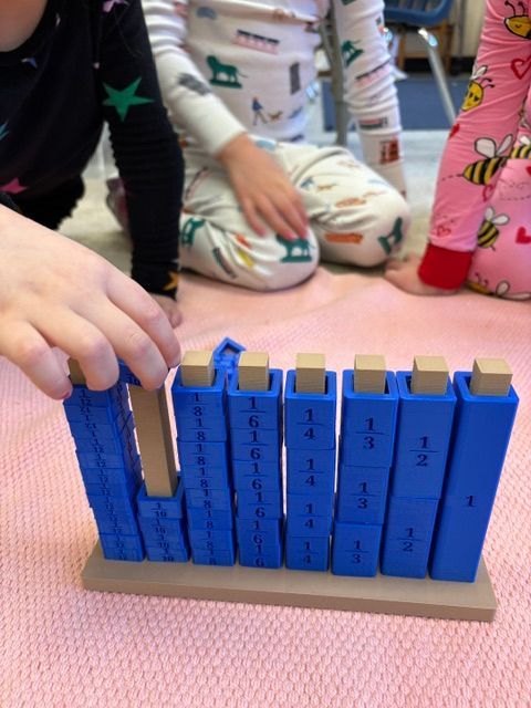A child is playing with a stack of blue blocks with fractions on them