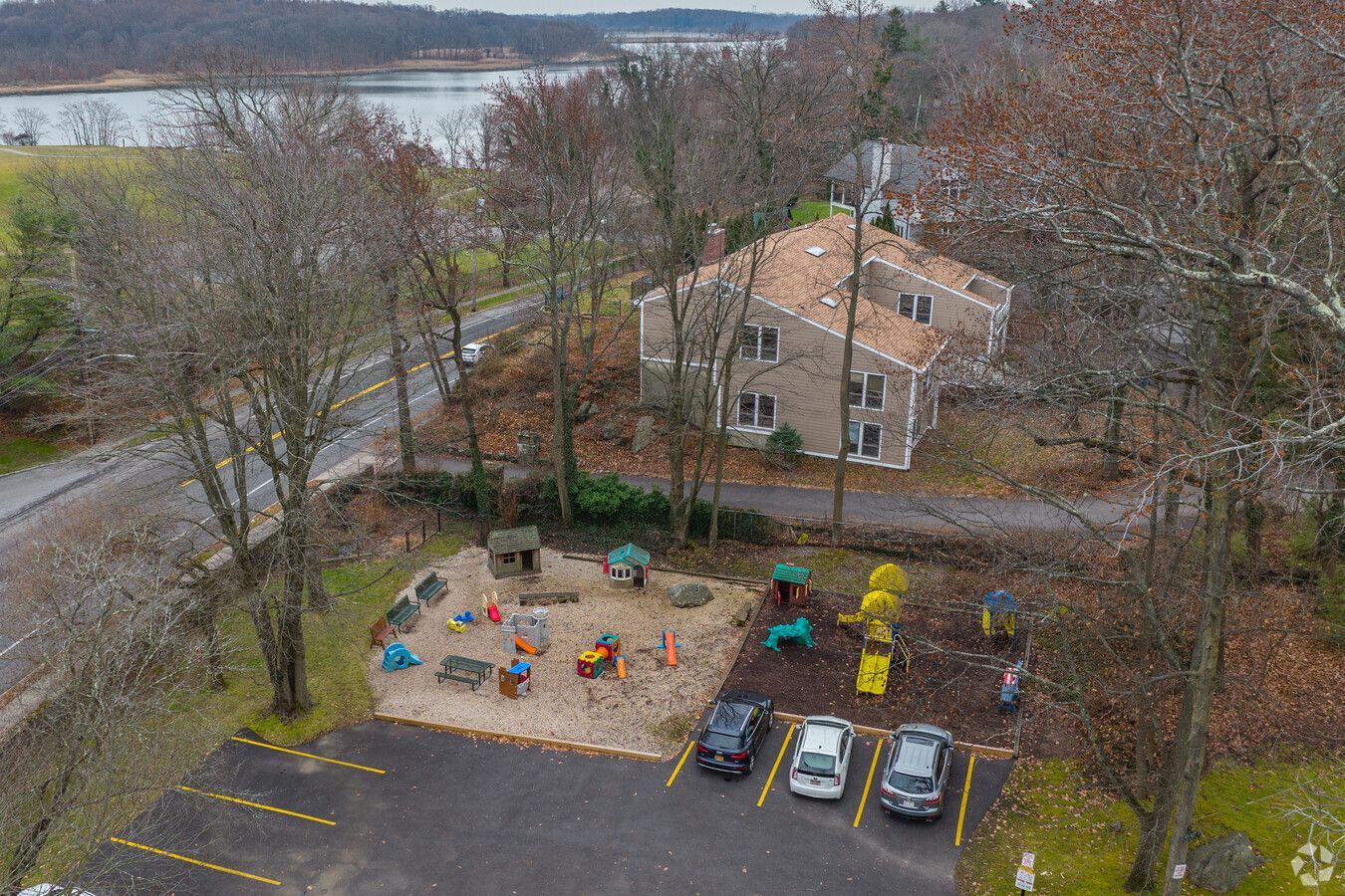 An aerial view of a playground with cars parked in front of it.