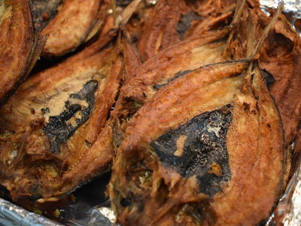 Close-up of fried, browned eggplant slices with dark charred sections.