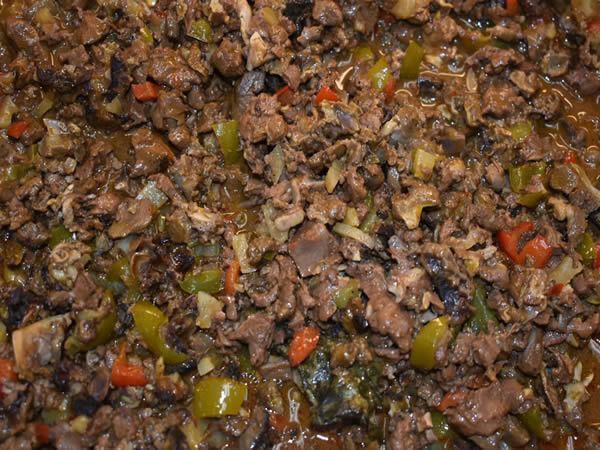 Sautéed meat dish with visible green and red peppers, likely a stew or similar recipe.