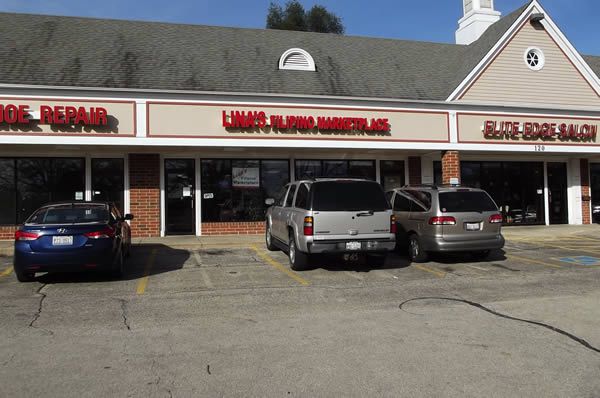 Shops in a strip mall: Shoe Repair, Limitless Barbershop, and Elite Edge Salon. Cars parked in front.