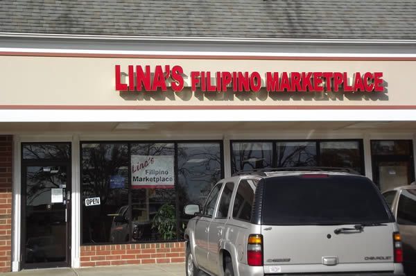 Lina's Filipino Marketplace storefront, red letters over windows, silver SUV parked in front.