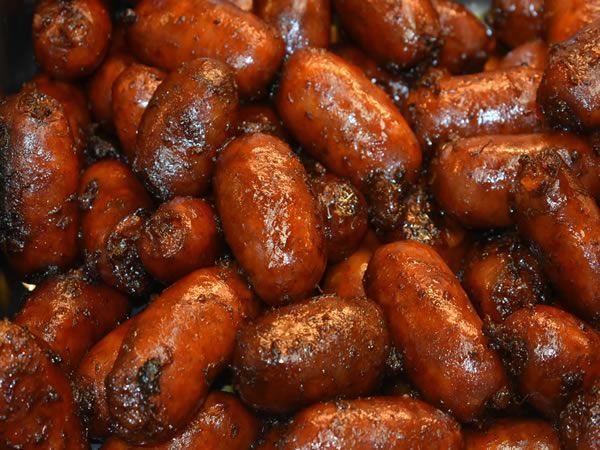 Pile of glazed, browned sausages, close up.