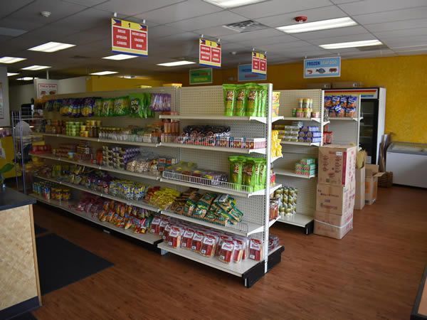 Interior of a convenience store with shelves of snacks and drinks.