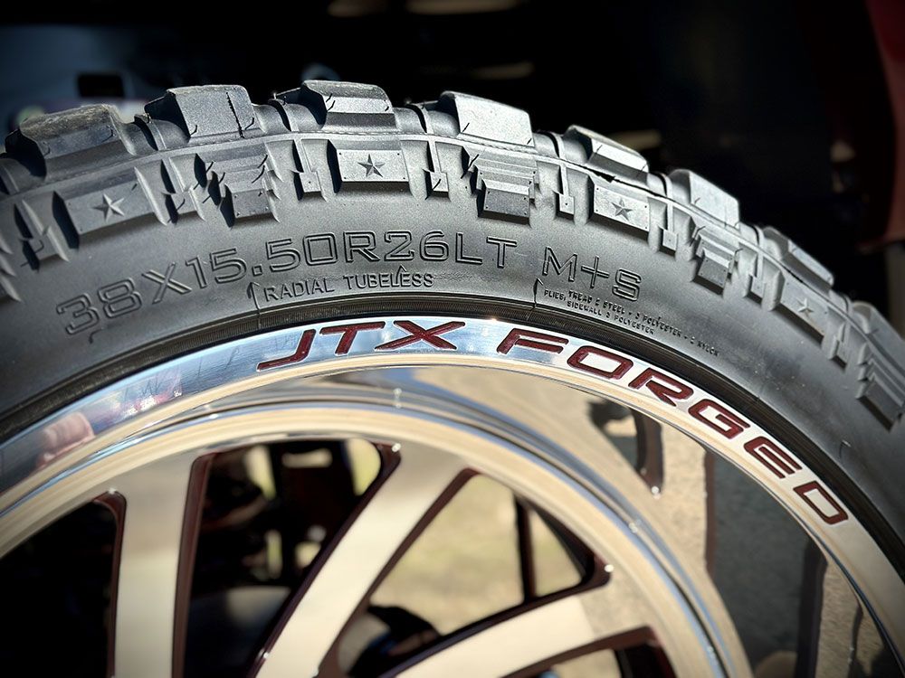 Close-up of a truck tire on a rim, with tire size 35x13.50R22LT and 