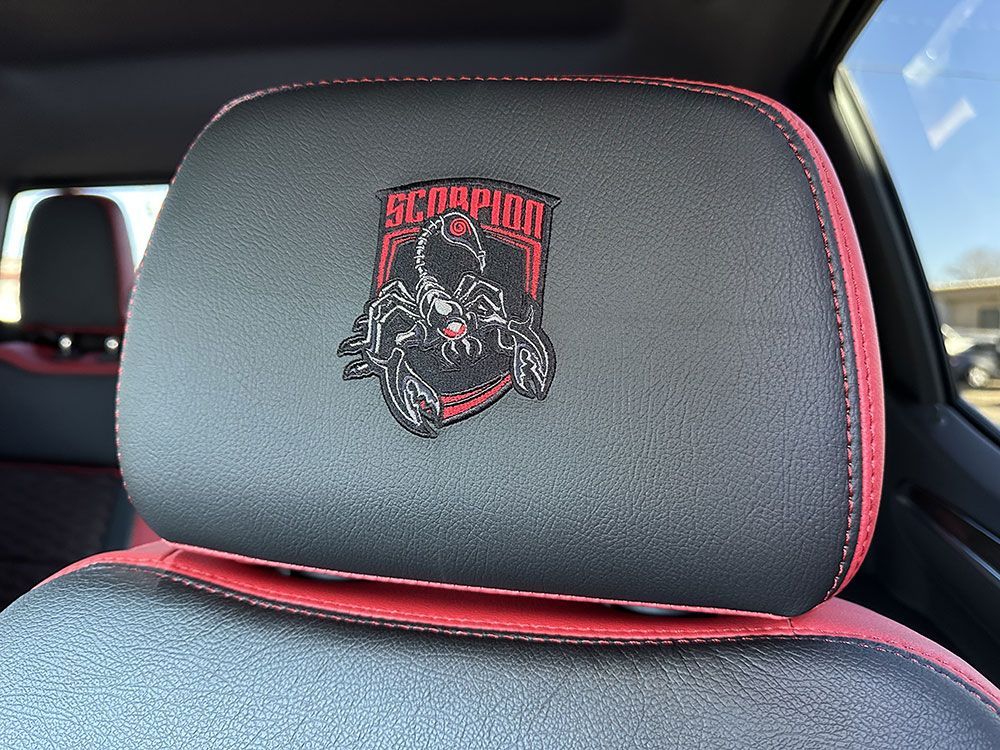 Black and red car seat headrest with a scorpion logo.