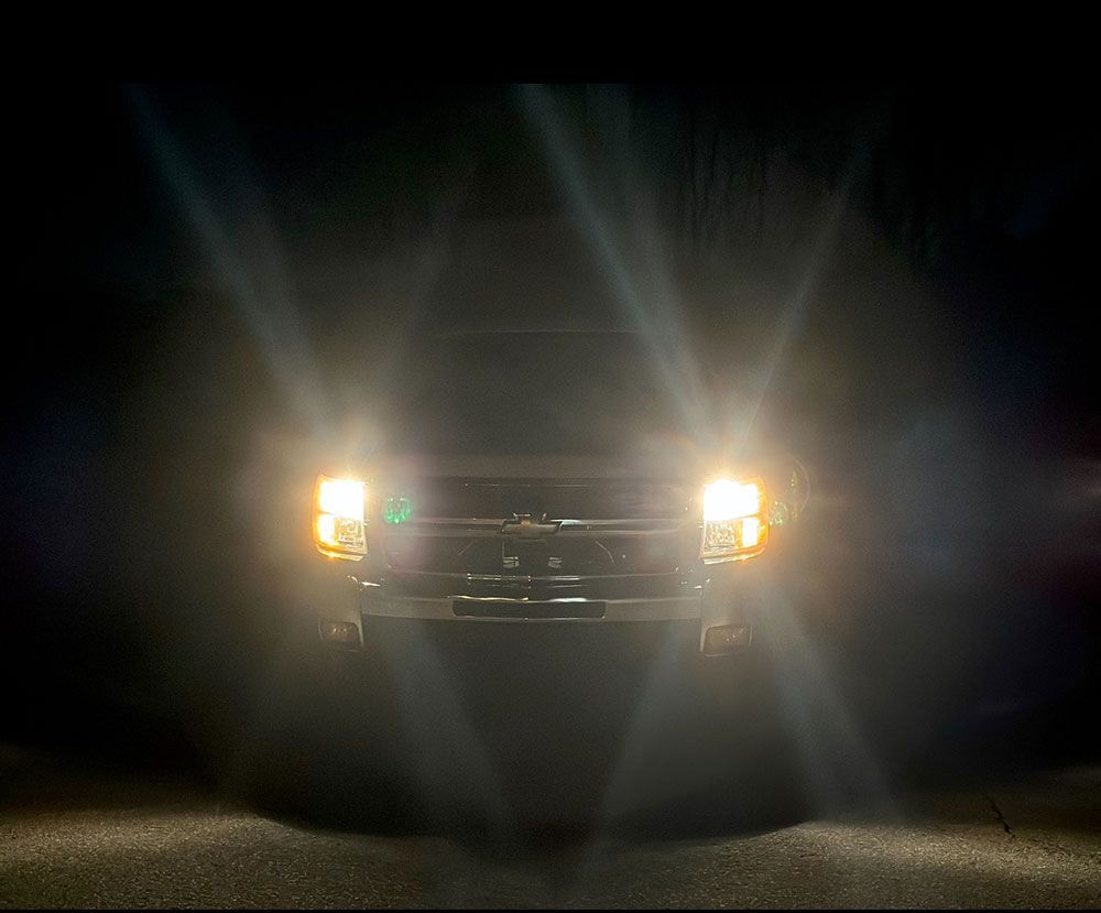 Truck with bright headlights shining in the dark.