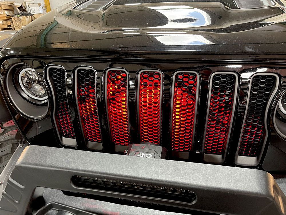 Black Jeep with red illuminated grill.