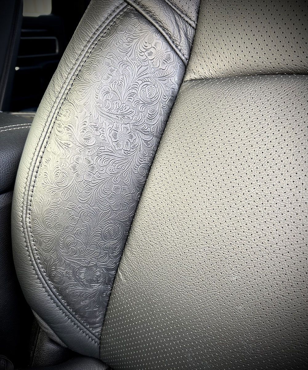 Close-up of a car seat. The left side of the seat appears worn and faded, while the right side is in better condition.