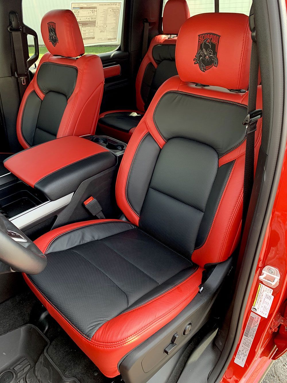 Red and black leather car seats with a ram logo in a red car.