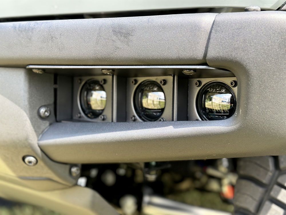 Three LED lights mounted in a vehicle bumper. Dark gray, metallic.