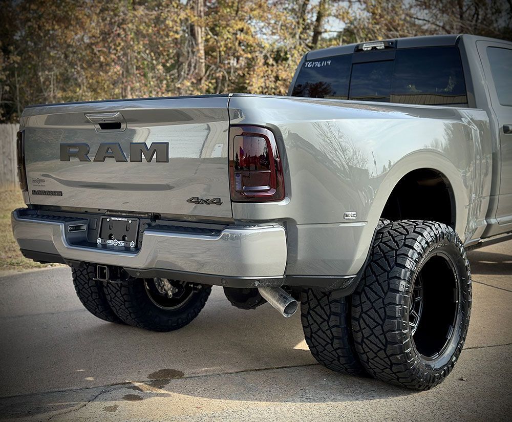 Gray Ram pickup truck with large black tires.