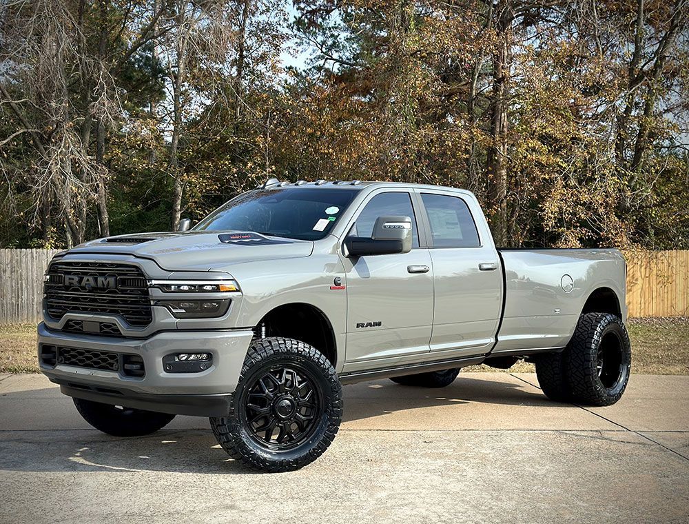 Gray Ram pickup truck with black wheels parked outdoors.