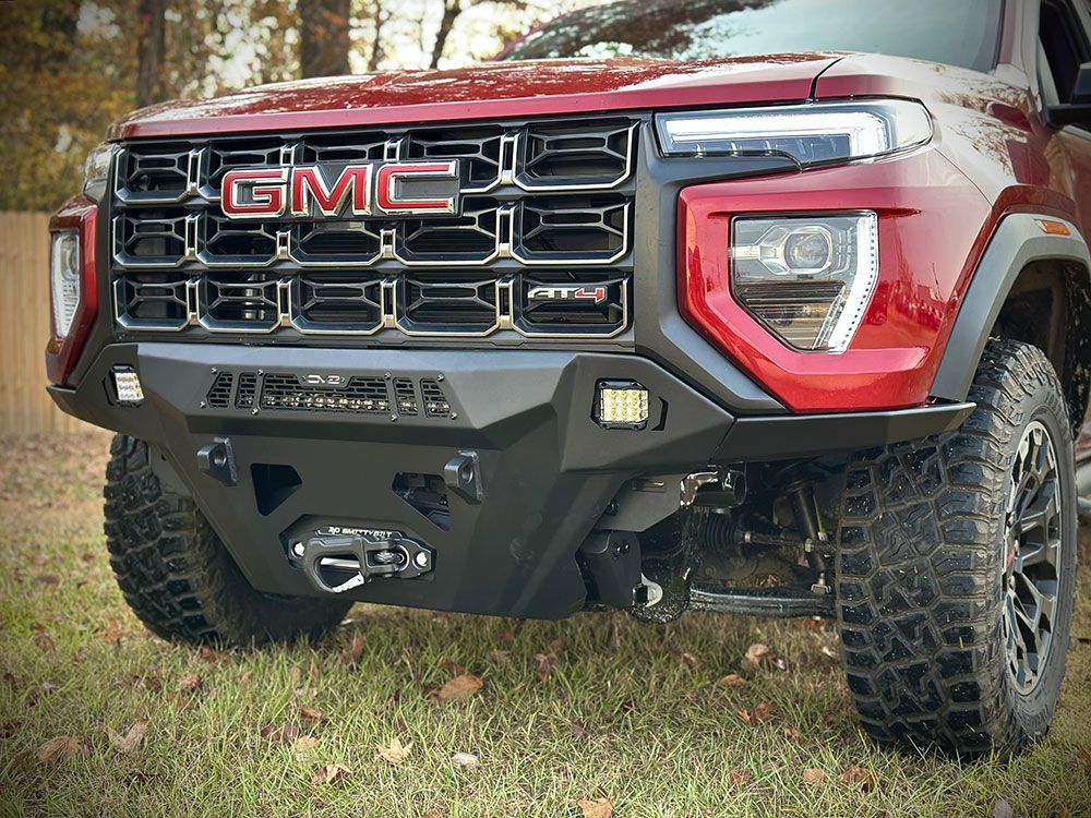 Red GMC truck with a black off-road bumper, winch, and grill.