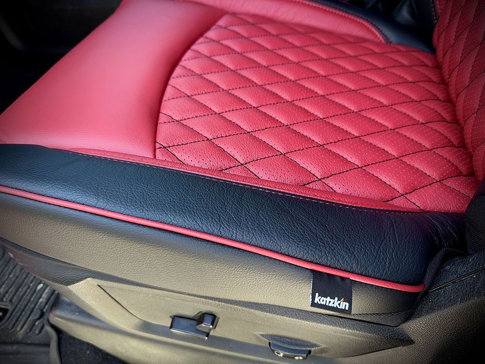 Red and black quilted car seat with black trim and a Kotchkin label.