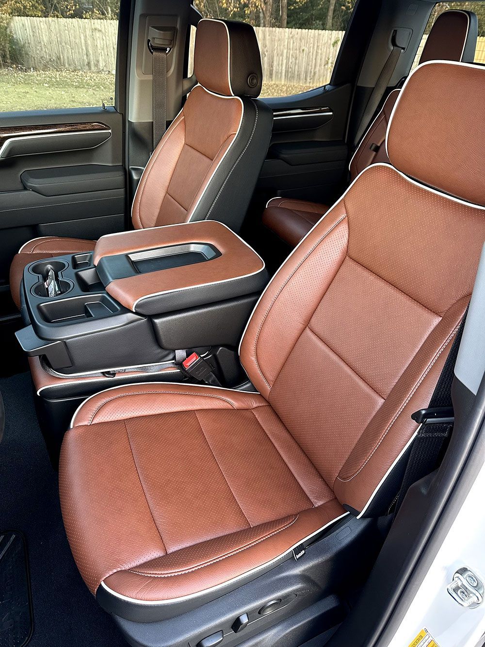 Brown leather truck interior with black and white trim; center console visible.