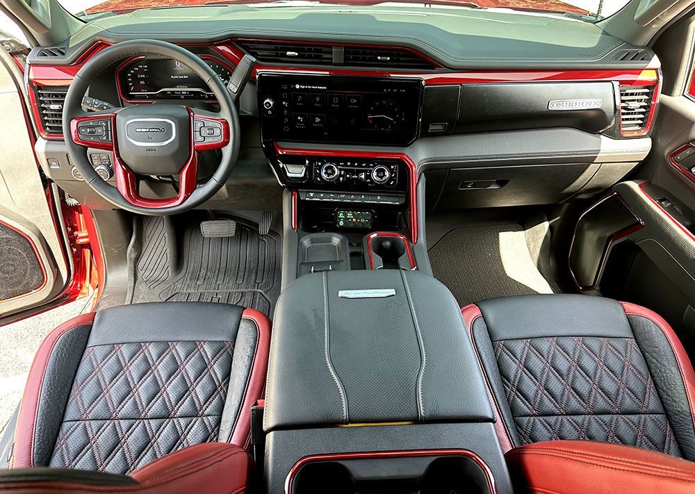 Red and black truck interior with quilted seats, dashboard, steering wheel and accents.