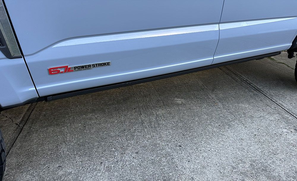 Side of a light blue pickup truck with a red 