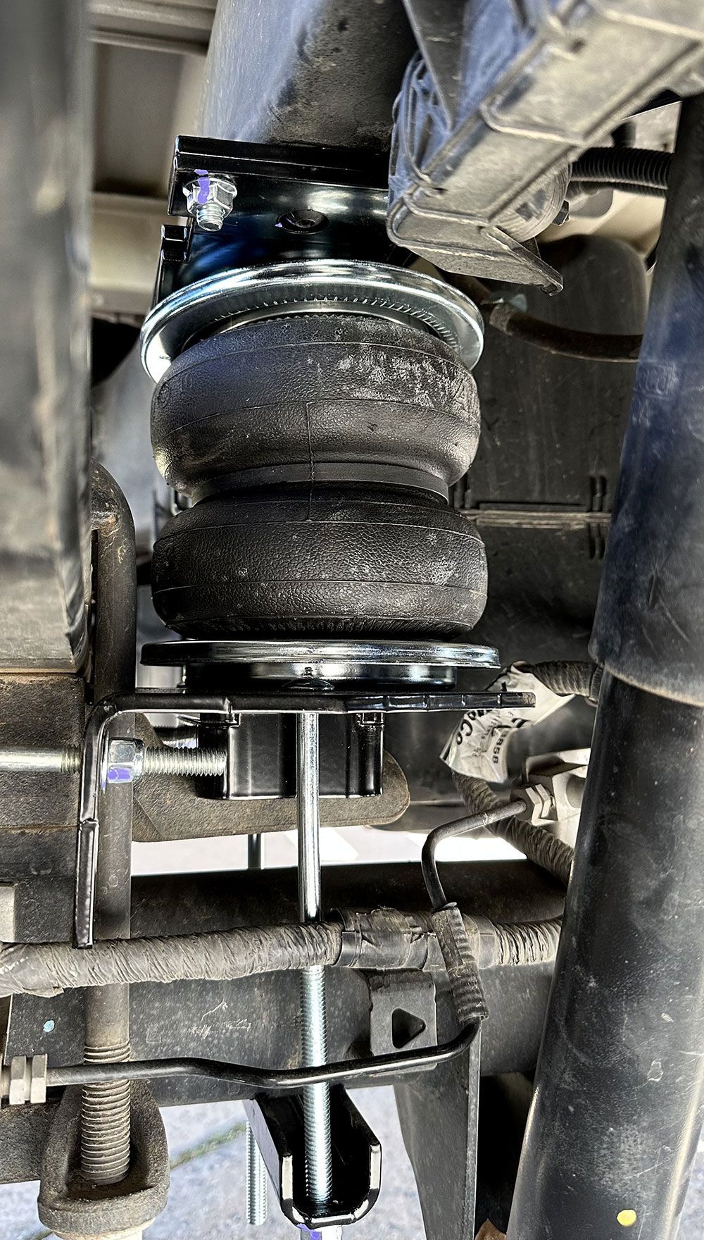 Black air spring suspension system installed on a vehicle's rear axle.