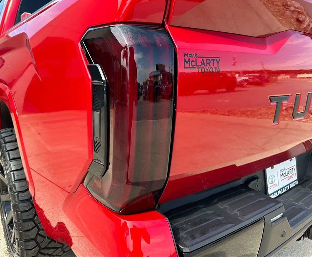 Red Toyota Tundra taillight, tinted, with black accents. McLarty Toyota logo visible.