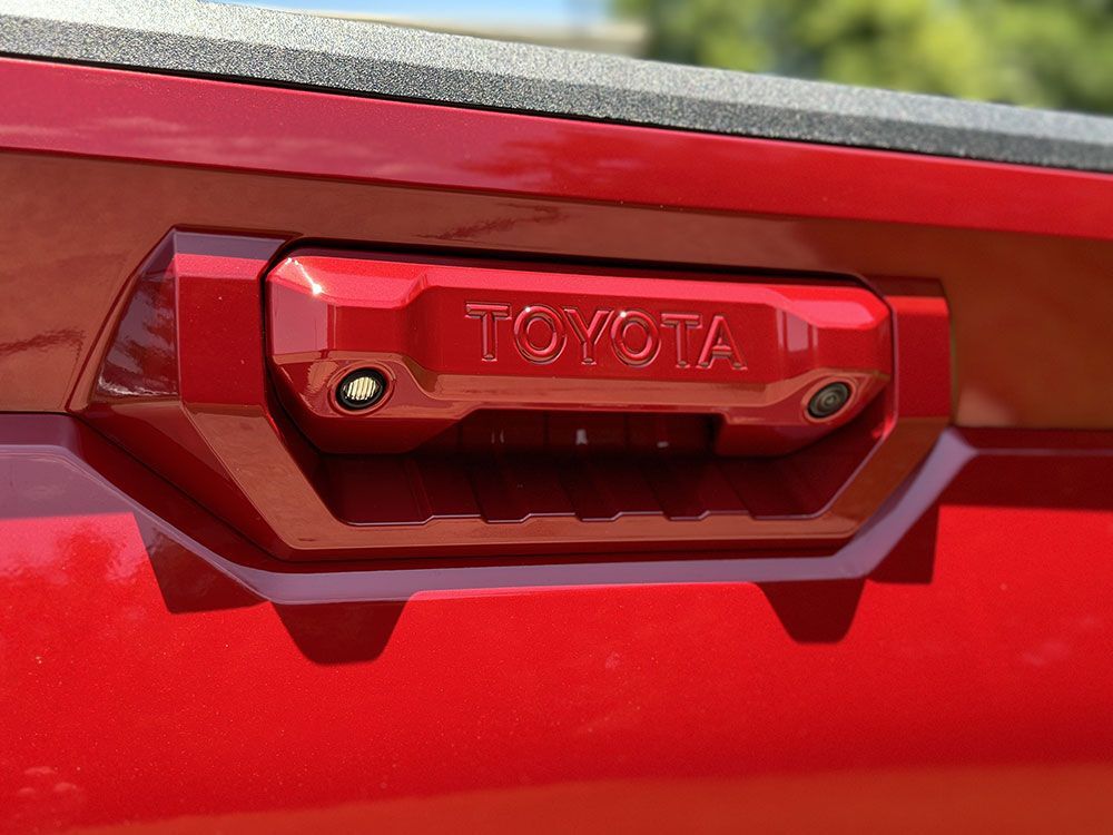 Red Toyota truck tailgate with a camera and 