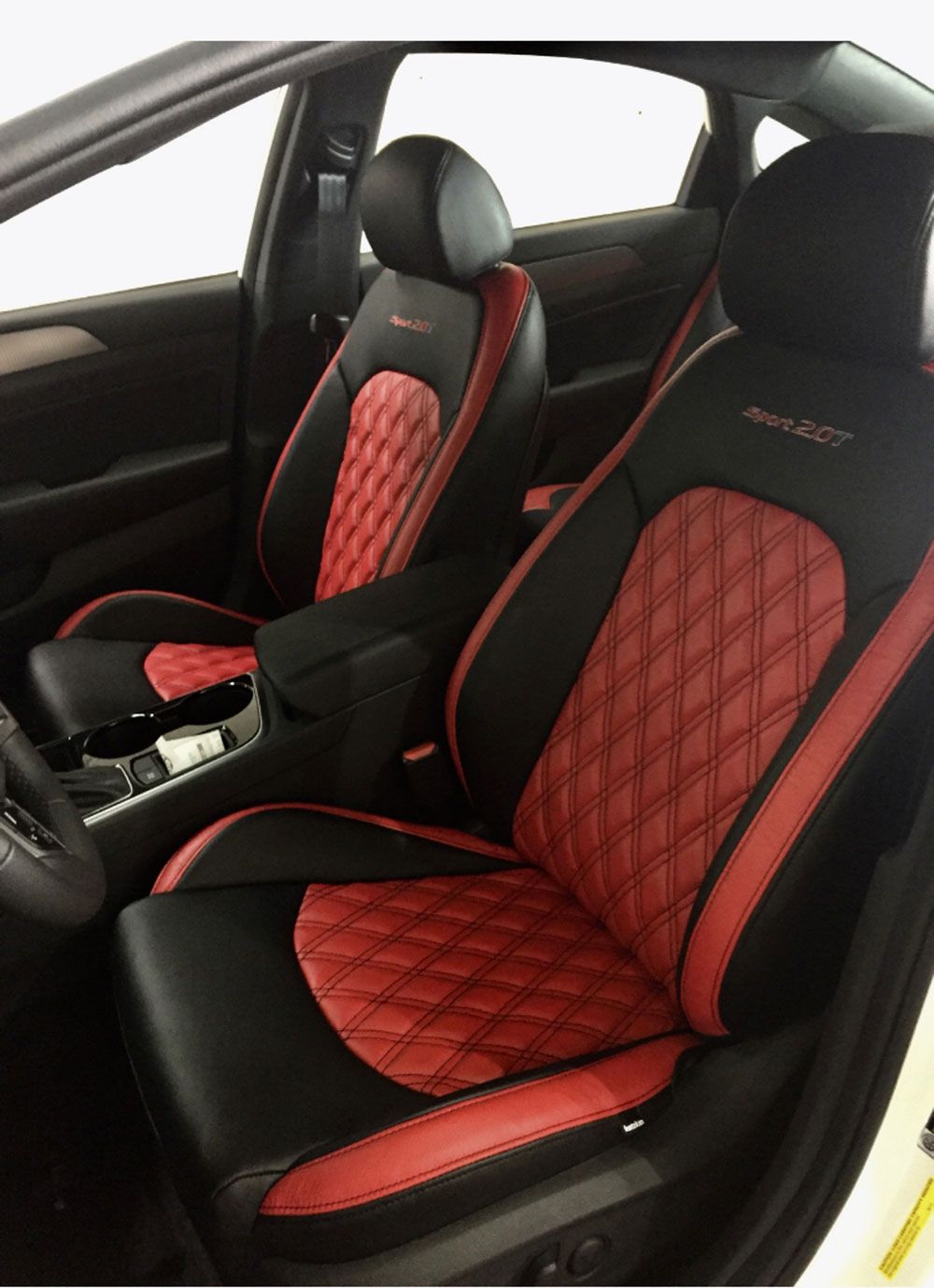 Black and red car seats with diamond stitching; interior shot.