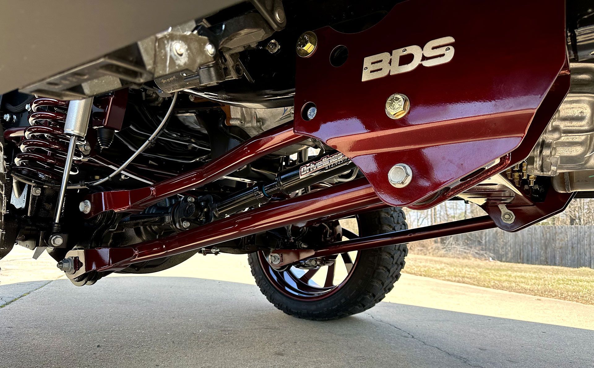 Red BDS suspension system on a truck, shot from a low angle.