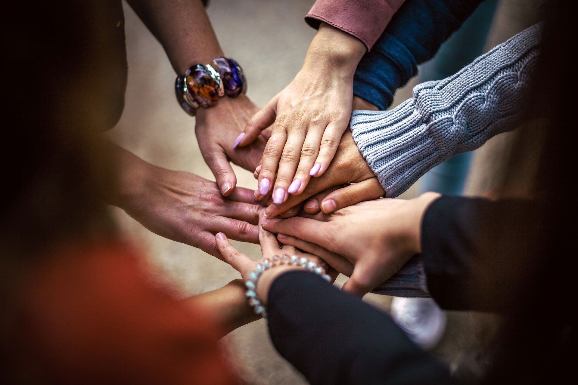 A group of people are putting their hands together.