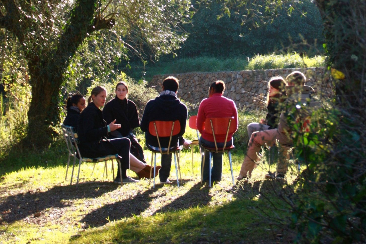 A group of people are sitting around a table in the grass