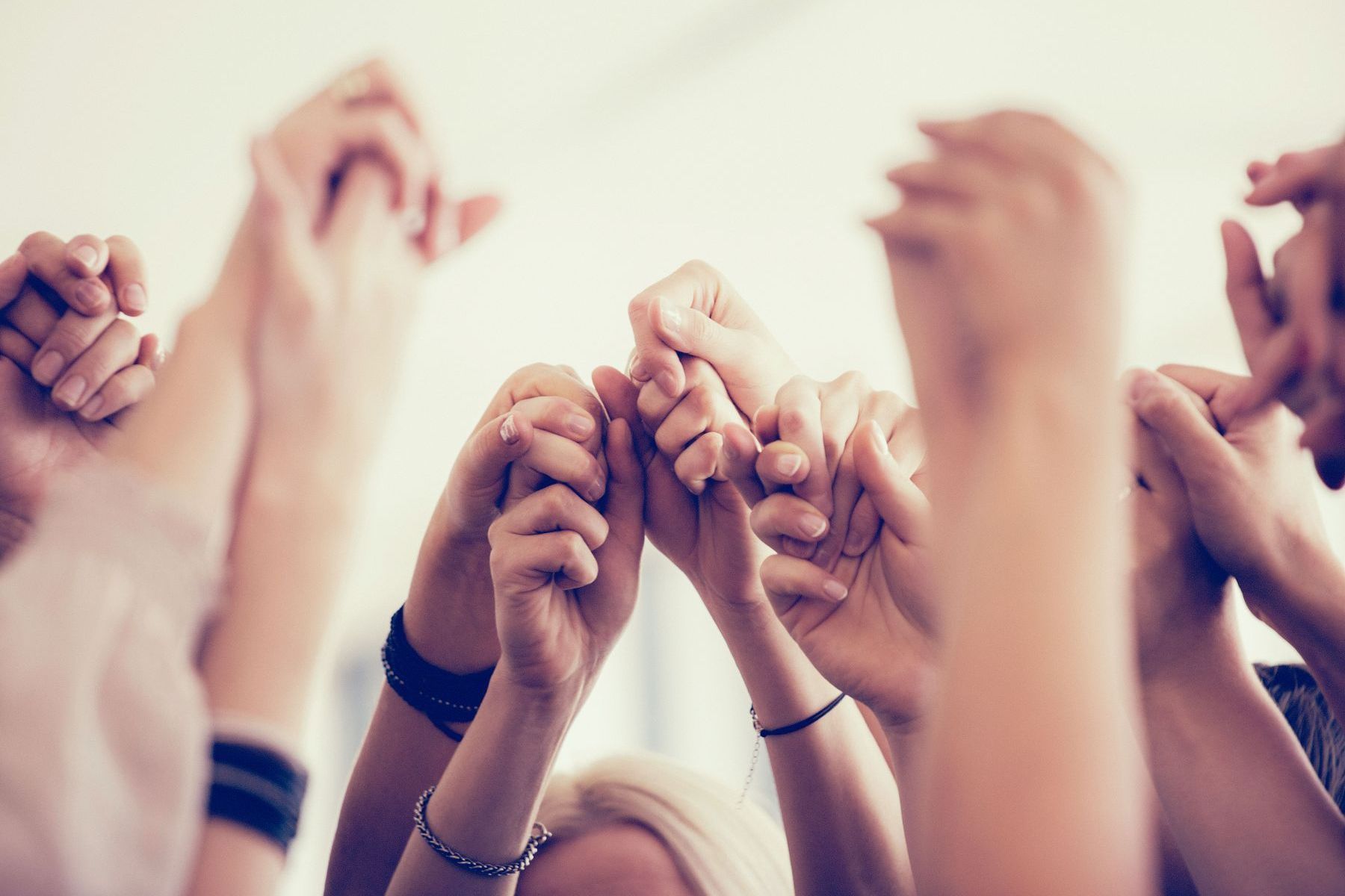 A group of people are holding their hands up in the air.