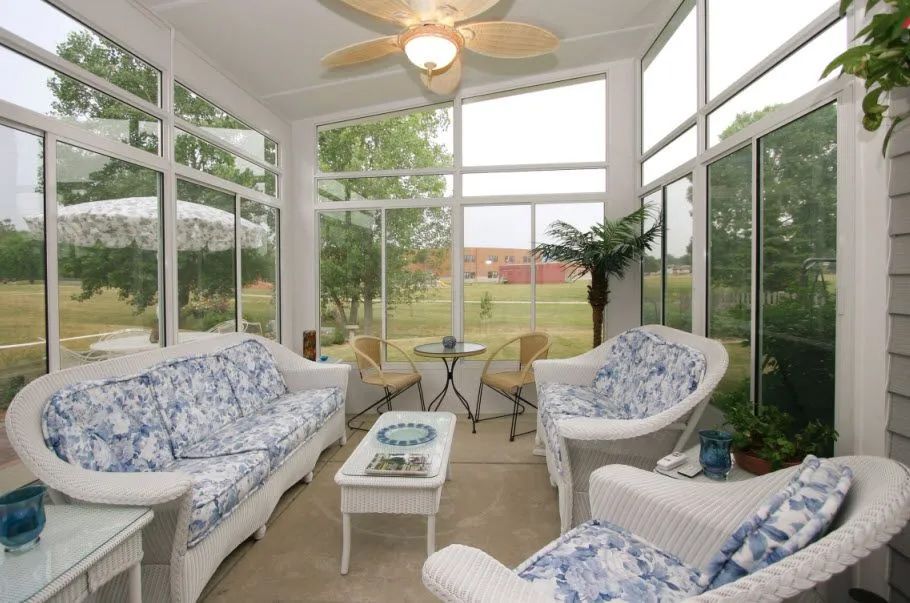 A living room with a couch and chairs and a ceiling fan