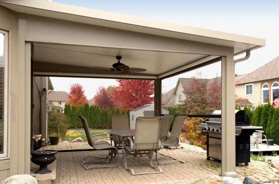 A patio with a table and chairs and a ceiling fan