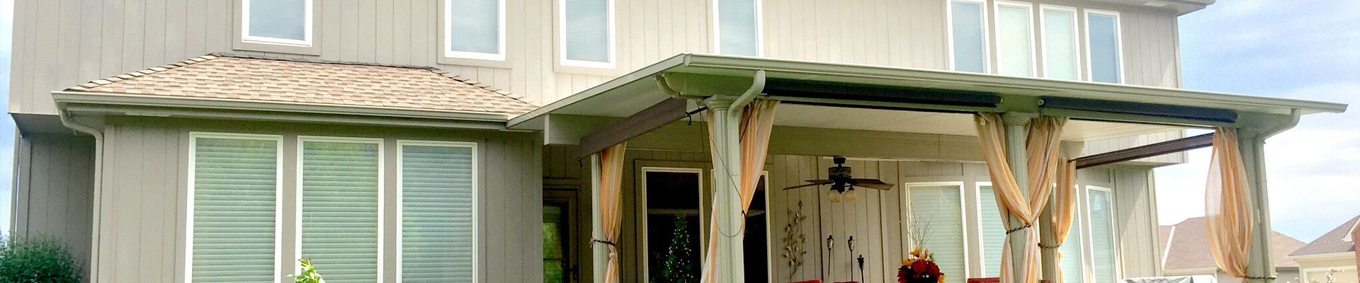 A large white house with a large porch and a pergola.