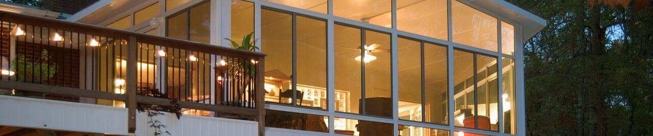 A large house with a lot of windows is lit up at night.