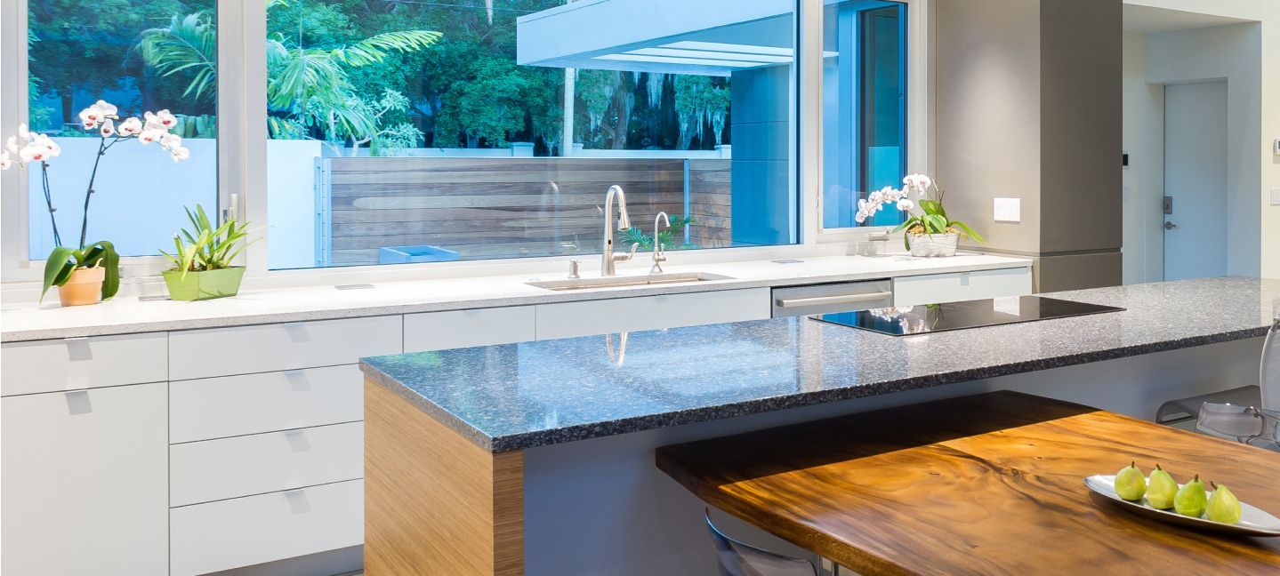 A kitchen with a wooden table and a large window.