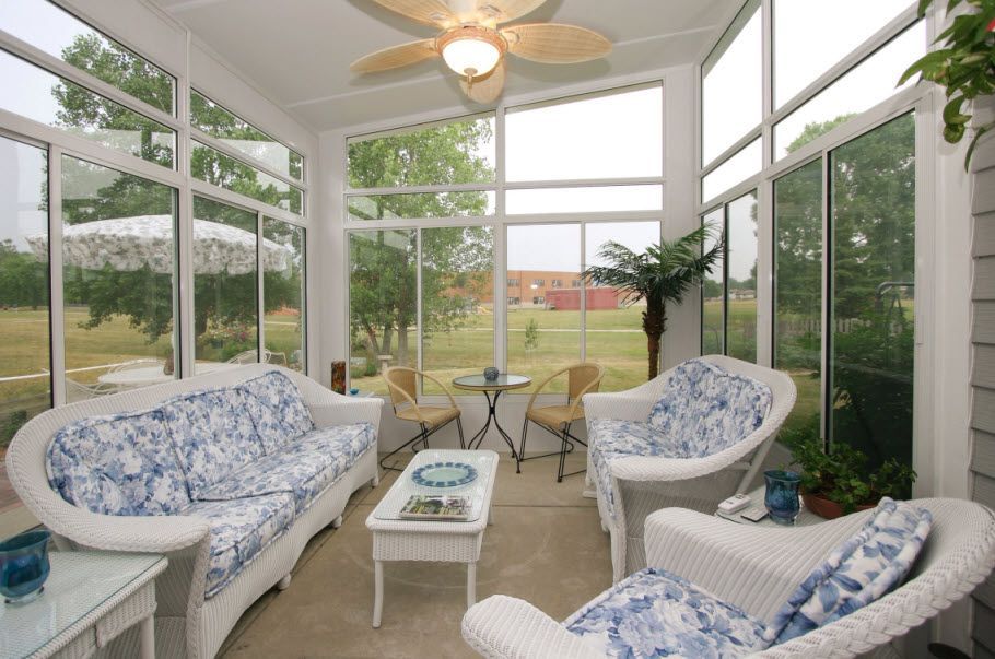 A living room with a couch and chairs and a ceiling fan